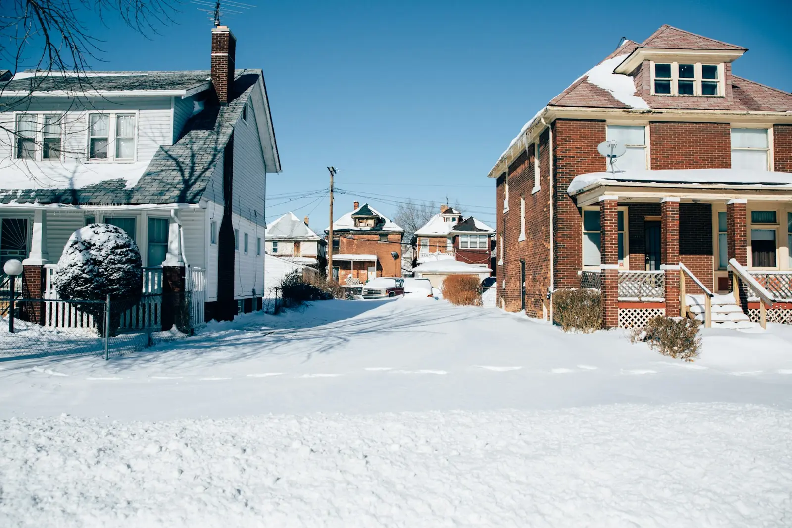 Snow-covered residential street showing the winter conditions concrete faces across Oakland and Macomb counties